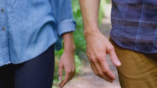 Close Up Of Loving Couple Holding Hands On Walk Along Path In Countryside Together